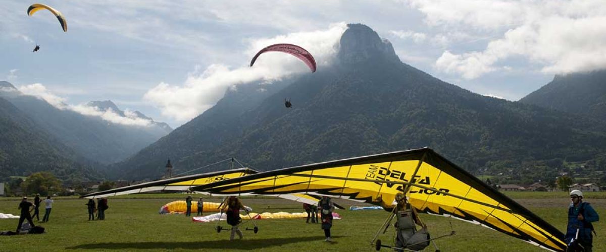 Deltaplanes en phase d'atterrissage avec vue sur les montagnes en arrière-plan