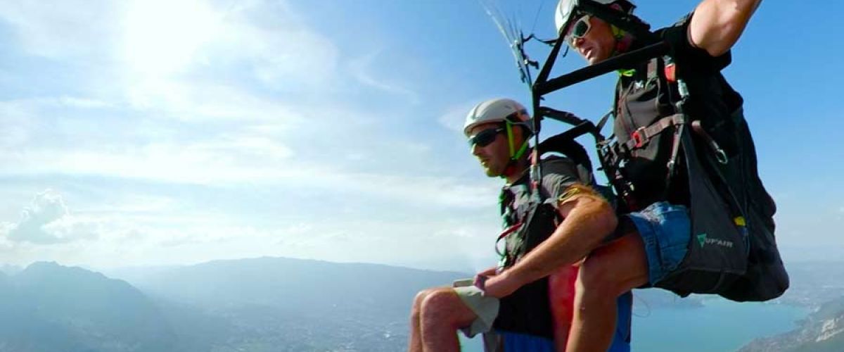 Parapente au-dessus du lac d'Annecy avec vue panoramique sur les montagnes