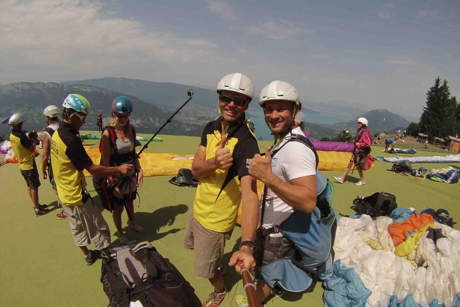 Personnes se préparant au décollage en parapente, vérifiant l'équipement et observant les conditions de vol