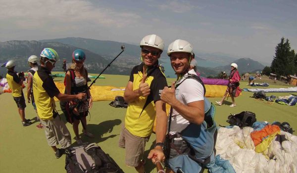 Personnes se préparant au décollage en parapente, vérifiant l'équipement et observant les conditions de vol