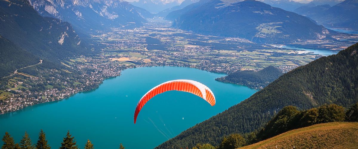 Parapente en vol au-dessus du lac d'Annecy, surplombant les eaux claires et les paysages alpins