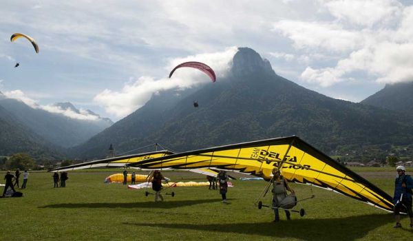 Deltaplanes en phase d'atterrissage avec vue sur les montagnes en arrière-plan