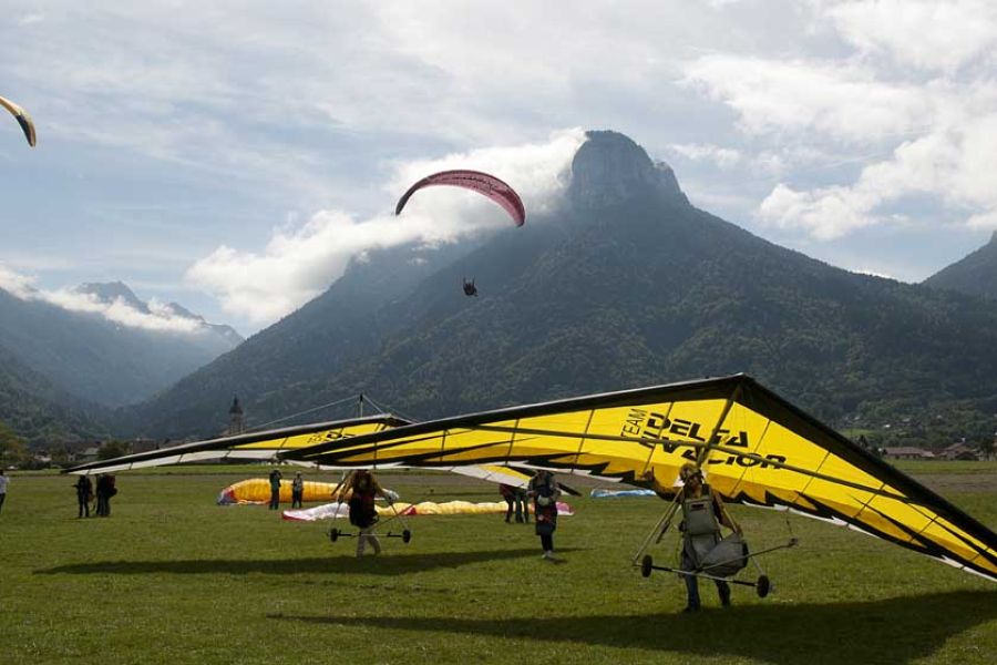 Deltaplanes en phase d'atterrissage avec vue sur les montagnes en arrière-plan