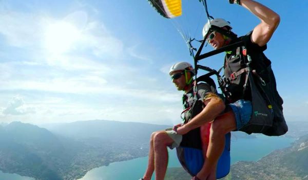 Parapente au-dessus du lac d'Annecy avec vue panoramique sur les montagnes