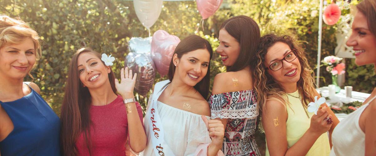 Un groupe de femmes rayonnantes célébrant un enterrement de vie de jeune fille, partageant des rires et des moments complices dans un cadre festif.