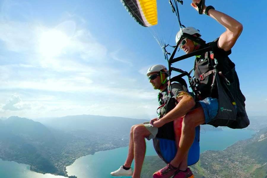 Parapente au-dessus du lac d'Annecy avec vue panoramique sur les montagnes